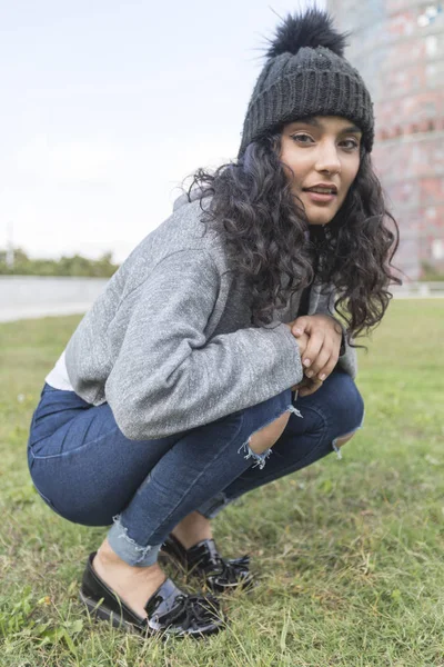 Retrato de una mujer con gorra de lana y suéter en el parque — Foto de Stock