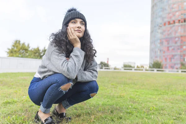 Retrato de una mujer con gorra de lana y suéter en el parque — Foto de Stock