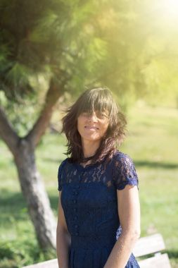 Bir parkta gülümseyen ve kameraya bakarak kadın