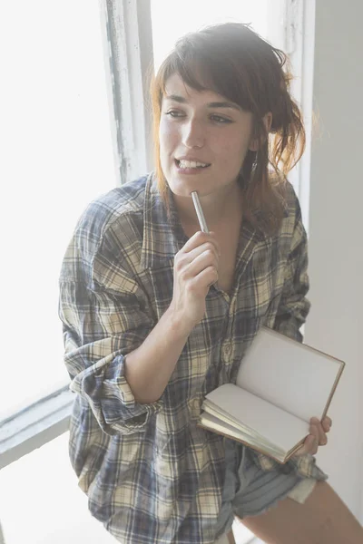 Escena matutina de una joven hipster escribiendo con la mano derecha en cuaderno — Foto de Stock