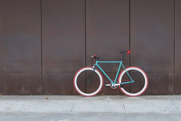 A City bicycle fixed gear on a brown wall — Stock Photo, Image