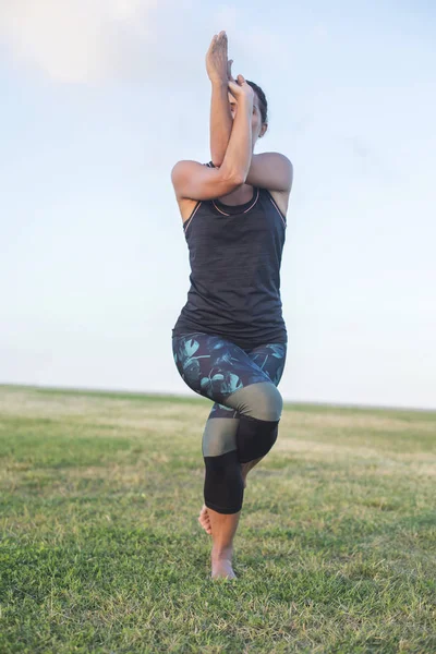 Egy fiatal nő, szabadtéri jóga a feladatot — Stock Fotó