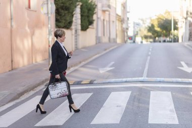 Kentsel ortamda yürüyüş bir çanta ile iş kadını. Kırmızı çantalı giyiyor
