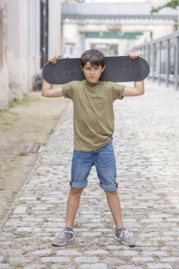 Close-up of a teenage boy carrying skateboard and smiling clipart