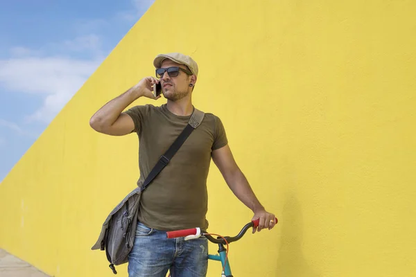 Stedelijke Man Met Een Telefoon Voor Een Gele Muur Straat — Stockfoto