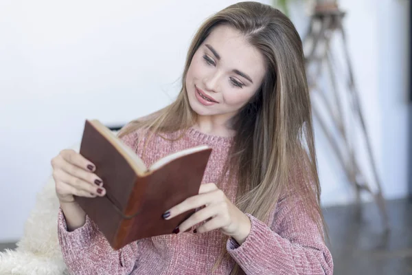 Uvolněná žena čte knihu na pohovce doma — Stock fotografie
