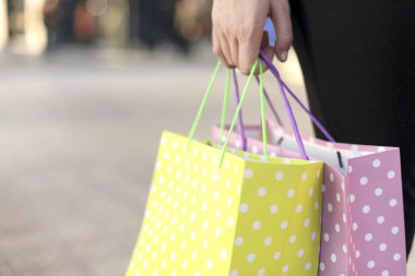 Closeup kopya s ile sokakta alışveriş torbaları tutan kadın