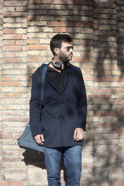 Ayakta ve omuz çantası taşıyan adam