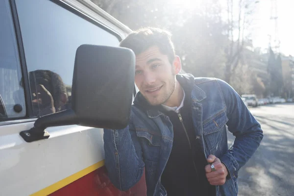 Ijdele man controleren zijn kijkt in de spiegel van zijn auto — Stockfoto