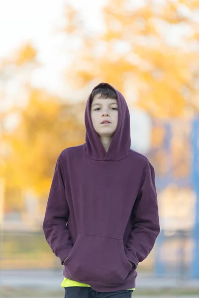 Portret van een jonge aantrekkelijke jongen in rode kap buitenshuis — Stockfoto