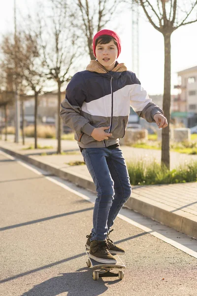 Skater-adolescente usando um chapéu de embarque na rua — Fotografia de Stock