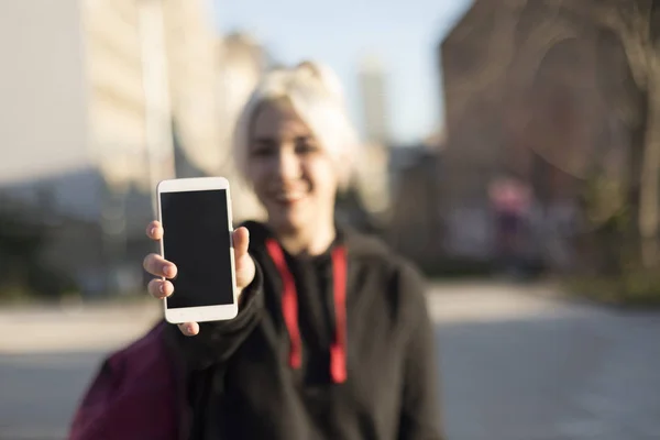 Frontansicht eines glücklichen Mädchens, das ein leeres Smartphone-Display zeigt — Stockfoto