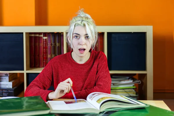 Mujer joven sorprendida mientras estudiaba en casa — Foto de Stock