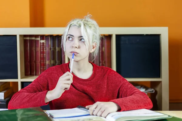 Attraktive junge blonde Frau studiert im Zimmer — Stockfoto