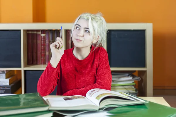 Attraktive junge blonde Frau studiert im Zimmer — Stockfoto