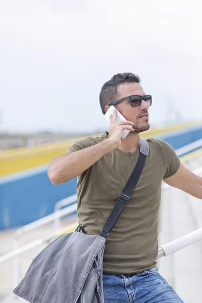 Urban man using a phone wearing sunglasses outdoors — Stock Photo, Image