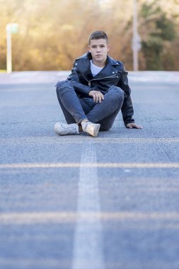 Şık genç bir deri ceket yolda oturan