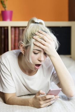 Bir telefon mes okunurken yatakta yatıyordu sürpriz genç kadın