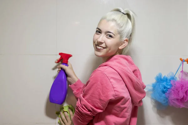 Una joven criada caucásica limpiando un baño — Foto de Stock