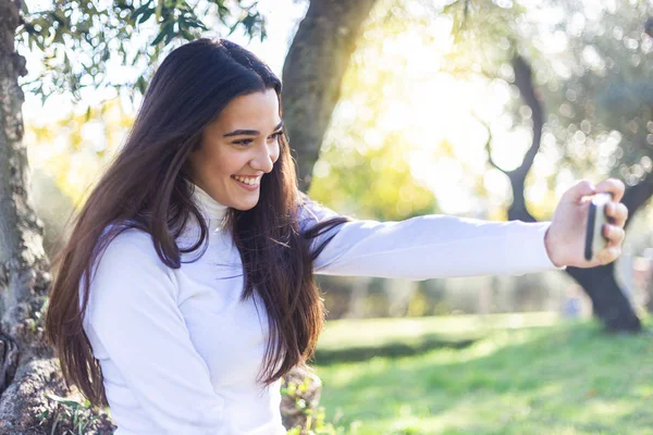 Beautiful young woman selfie in the park — Stock Photo, Image