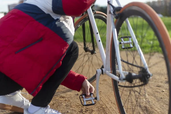 Fiatalember javítja a kerékpárját a szabadban az utcán — Stock Fotó