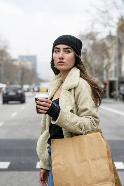一个欧洲女人提着外卖咖啡走在城市街道上的画像 — 图库照片