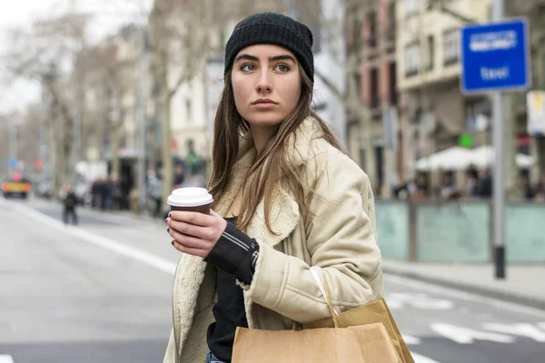一个欧洲女人提着外卖咖啡走在城市街道上的画像 — 图库照片