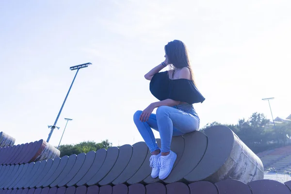 Eine Junge Schöne Frau Mit Langen Haaren Sitzt Der Promenadenwand — Stockfoto