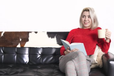 Oturma odasında kitap okuyan güzel bir kadın..