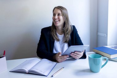 Genç girişimci kadın evde çalışıyor, iş yazıları yazıyor.