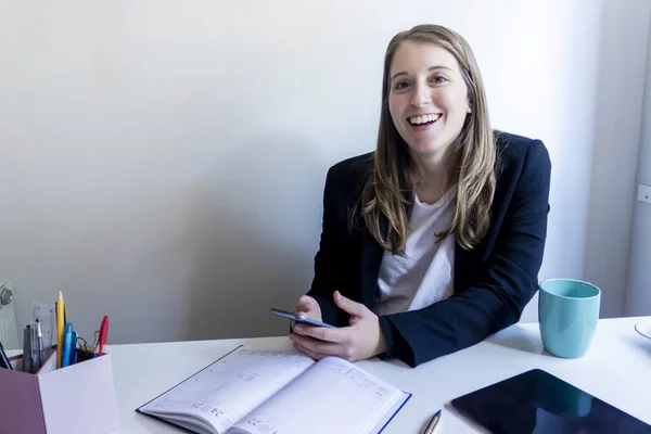 Joven Emprendedora Sonriente Mujer Sosteniendo Teléfono Móvil Mientras Trabaja Casa — Foto de Stock