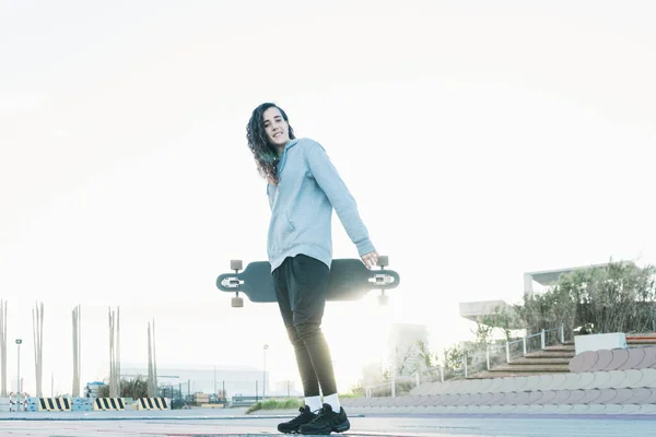 Młoda Nastolatka Patrzy Kamerę Trzymając Longboard — Zdjęcie stockowe