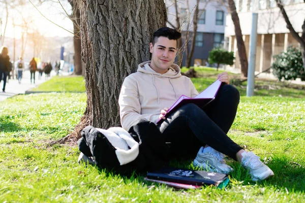 Adolescente Sentado Césped Escuela Mientras Estudia Con Libro — Foto de Stock
