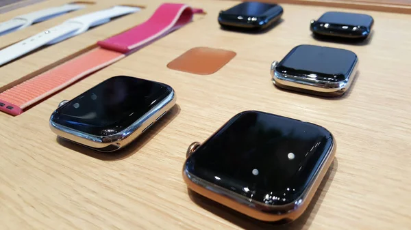 Часть часов Apple, таких как ремень, экран, показаны в деревянном столе в Apple Store I:am . — стоковое фото