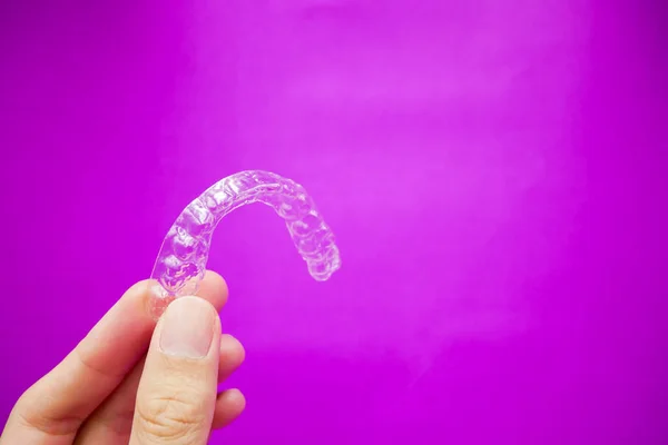 Mão Segurando Dentes Plástico Transparente Retentor Que Isolado Fundo Roxo — Fotografia de Stock