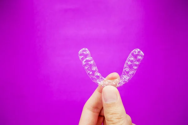 Mão Segurando Dentes Plástico Transparente Retentor Que Isolado Fundo Roxo — Fotografia de Stock