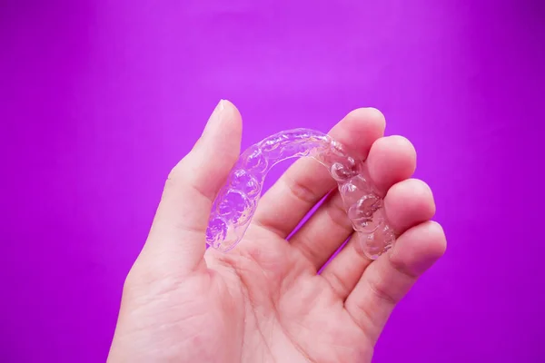 Mão Segurando Dentes Plástico Transparente Retentor Que Isolado Fundo Roxo — Fotografia de Stock