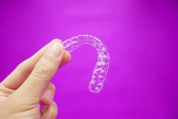 Mão Segurando Dentes Plástico Transparente Retentor Que Isolado Fundo Roxo — Fotografia de Stock