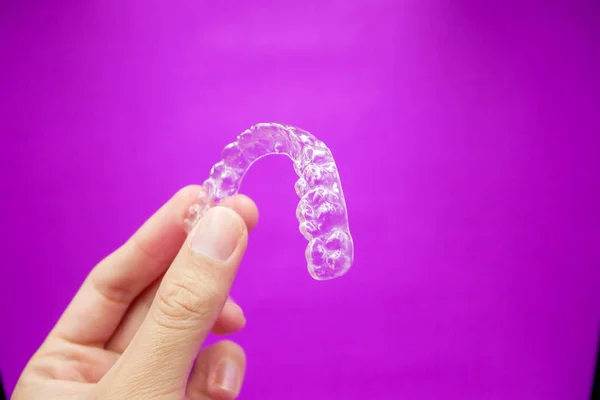 Mão Segurando Dentes Plástico Transparente Retentor Que Isolado Fundo Roxo — Fotografia de Stock