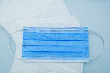 Maskenin korunmasına yardımcı olan tıbbi maske ağız ve burnu virüs, bakteri, toz veya diğer kirlilikten korur. Maske, izole edilmiş açık mavi arkaplanda alınır.