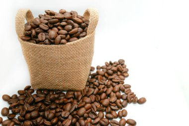 İzole edilmiş beyaz arka planda, eski bir çuvaldaki kahve çekirdekleri.