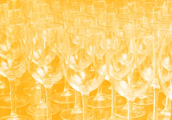 Κοντινές σειρές από άδεια ποτήρια κρασιού σε χρωματιστό φόντο στο χρώμα 2020. Κίτρινο χρώμα τάση μέχρι το 2020 — Φωτογραφία Αρχείου