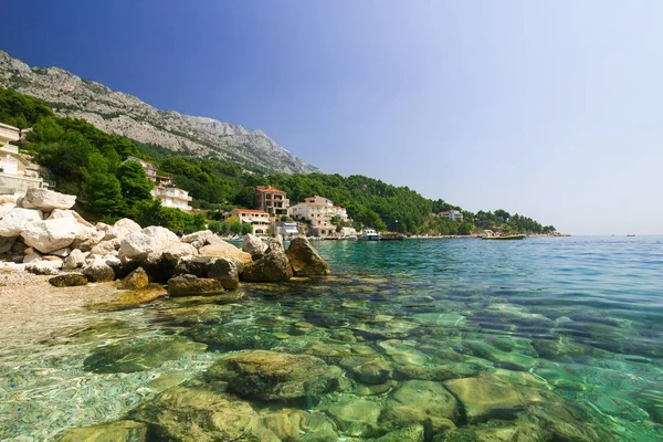 Hermoso paisaje de vacaciones de playa rocosa, mar y montañas —  Fotos de Stock