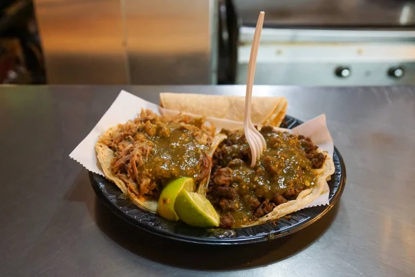 İki taco, bir tabakta biftek ve domuz eti.