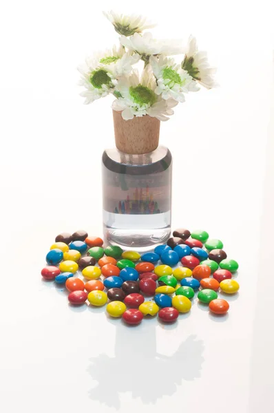 Fleurs maman dans un vase et bonbons au chocolat sur fond blanc — Photo
