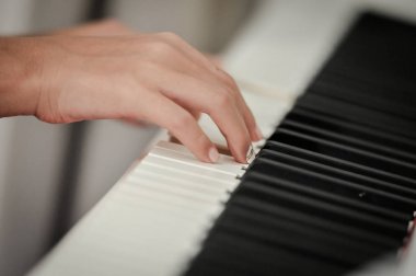 Dijital piyano el. Yakın çekim. Küçük alan derinliği.