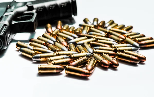 Close up of 9 mm. bullets with 9 mm. handgun in background — Stock Photo, Image