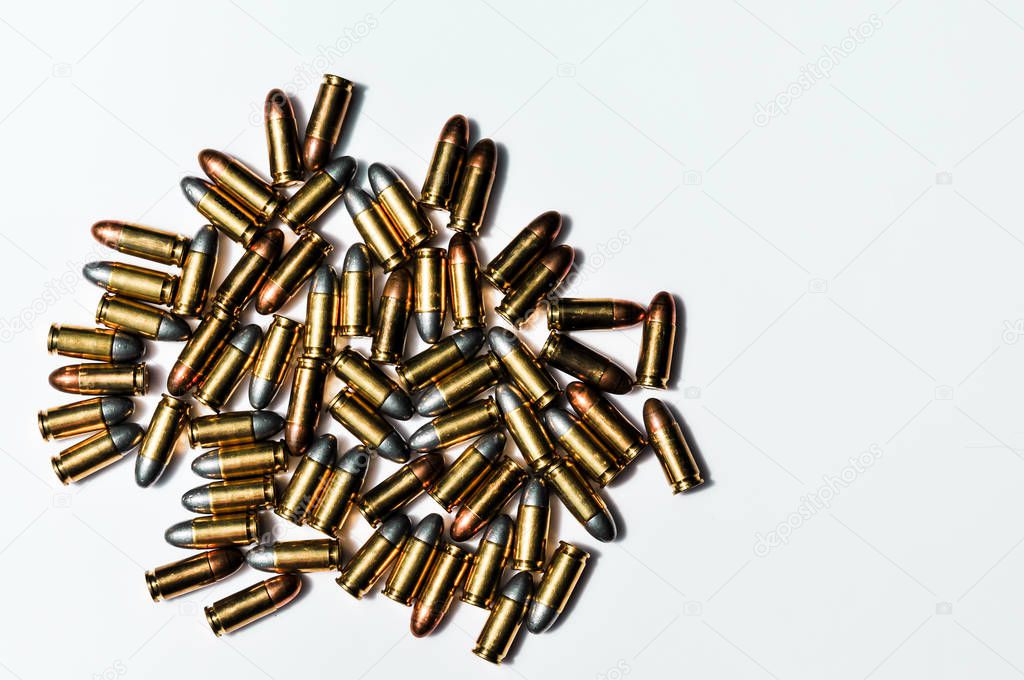 Close up of 9 mm. bullets with 9 mm. handgun in background