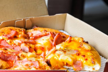 Mukavva içinde çeşitli malzemeler ve peynirli pizzaları kapatın. Açık kapaklı kutuları çıkarın.