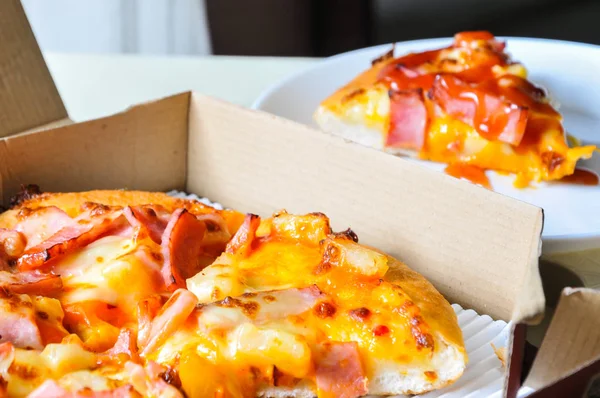 Mukavva içinde çeşitli malzemeler ve peynirli pizzaları kapatın. Açık kapaklı kutuları çıkarın.